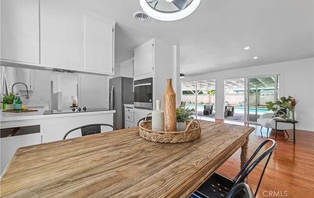 a kitchen with a table chairs stove and white cabinets