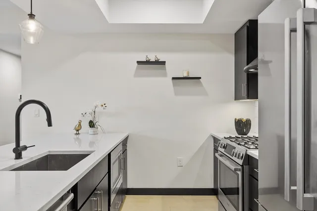 a kitchen with stainless steel appliances a sink and a refrigerator