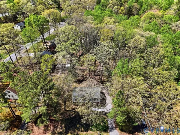 a view of a house with a lush green forest