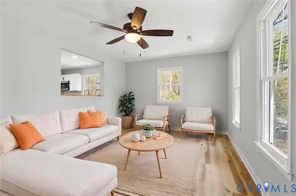 a living room with furniture and a wooden floor