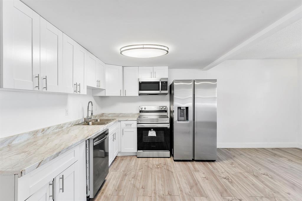 a kitchen with stainless steel appliances granite countertop a stove a sink and a refrigerator