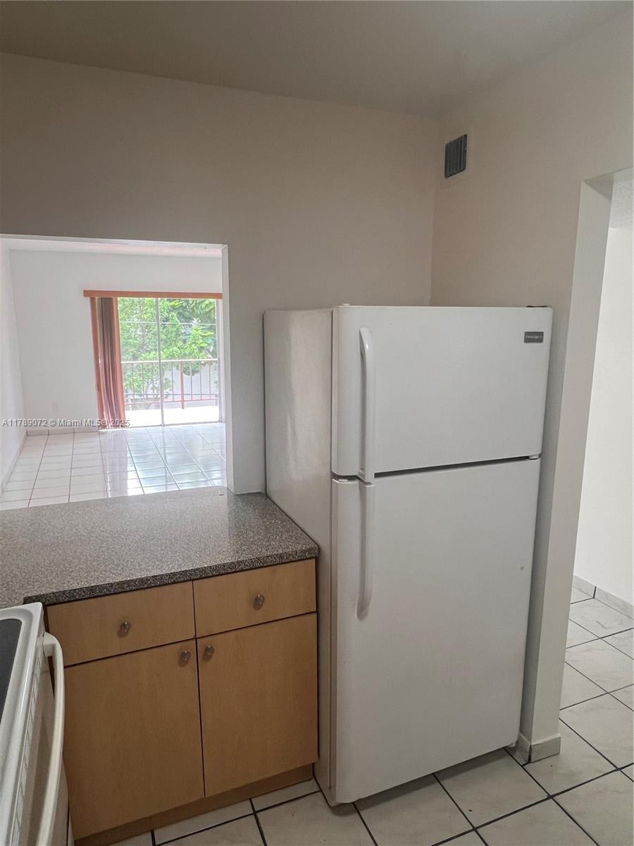 10851 Southwest 2nd Street, Unit K304 Sweetwater, FL 33174 - Photo 6 of 16 a kitchen with a refrigerator and window