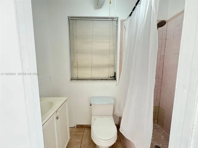 a white toilet sitting next to a bathroom sink and vanity