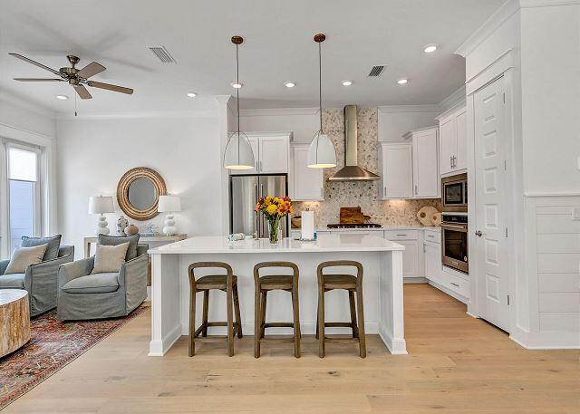 144 Wharf Ln Inlet Beach, Unit A Inlet Beach, FL 32461 - Photo 6 of 48 a kitchen with stainless steel appliances granite countertop a stove a sink a refrigerator and white cabinets with wooden floor