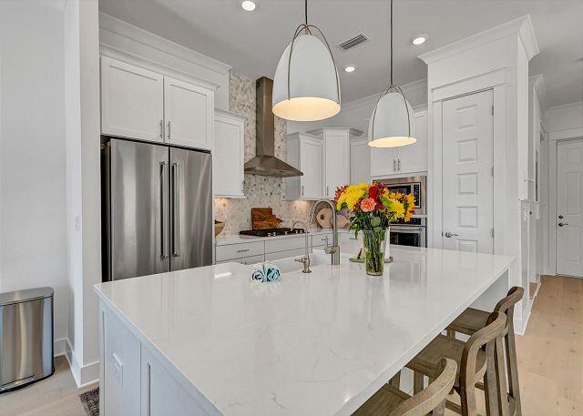144 Wharf Ln Inlet Beach, Unit A Inlet Beach, FL 32461 - Photo 7 of 48 a kitchen with stainless steel appliances a table chairs and a refrigerator