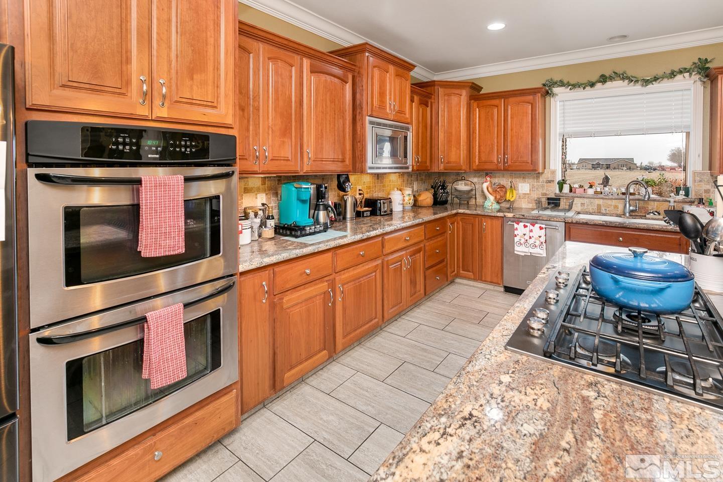 3774 Red Mountain Road Fallon, NV 89406 - Photo 11 of 37 a kitchen with stainless steel appliances kitchen island granite countertop a stove a sink and a microwave