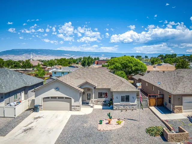 a front view of a house with a yard and lake view