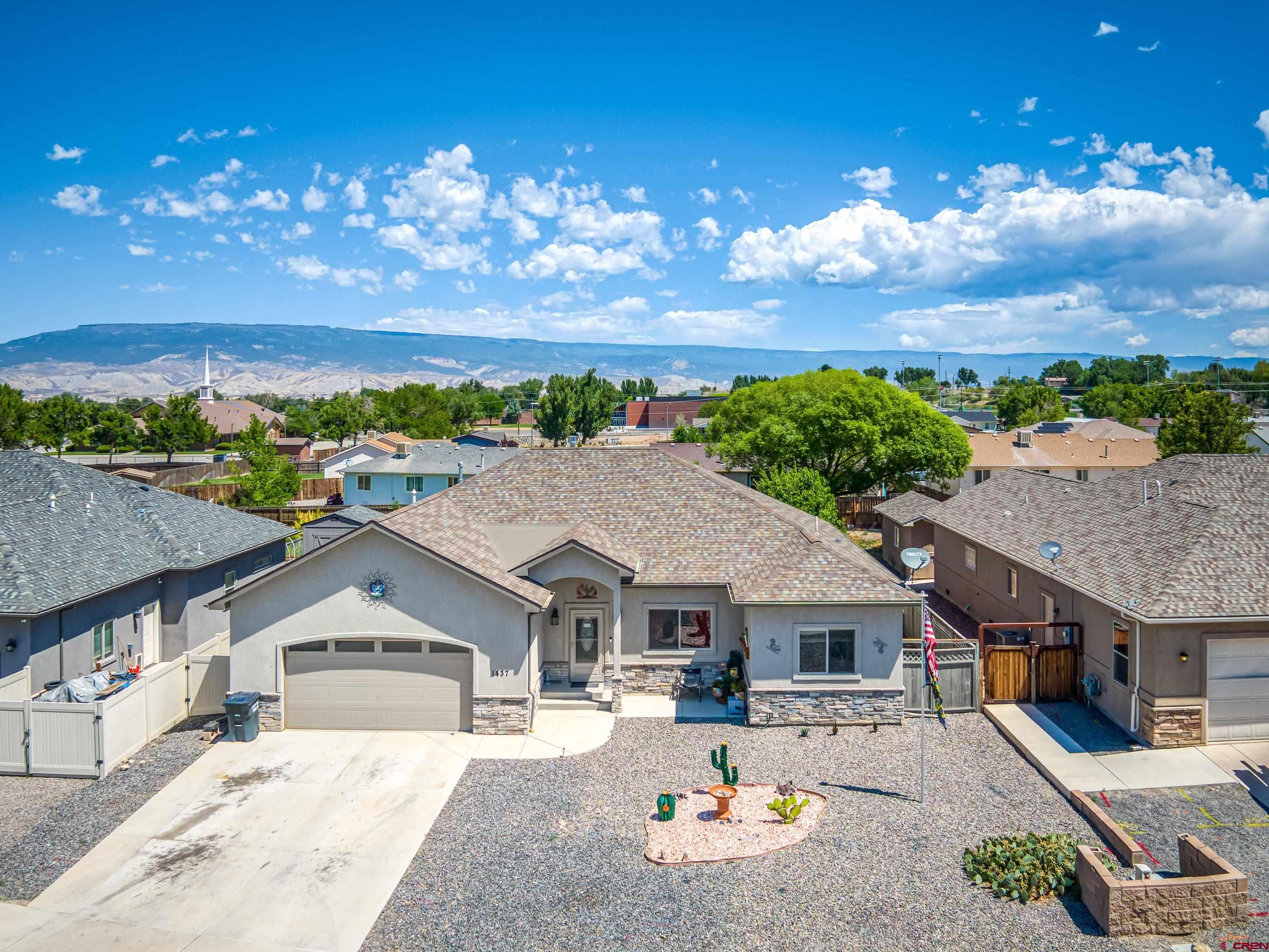 a front view of a house with a yard and lake view