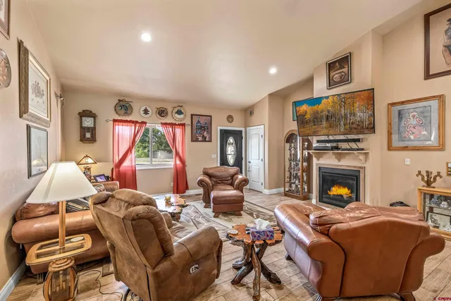 a living room with furniture a flat screen tv and a fireplace