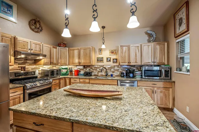 a kitchen with stainless steel appliances granite countertop a stove and more cabinets