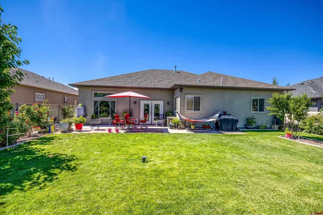 a view of a house with backyard and sitting area