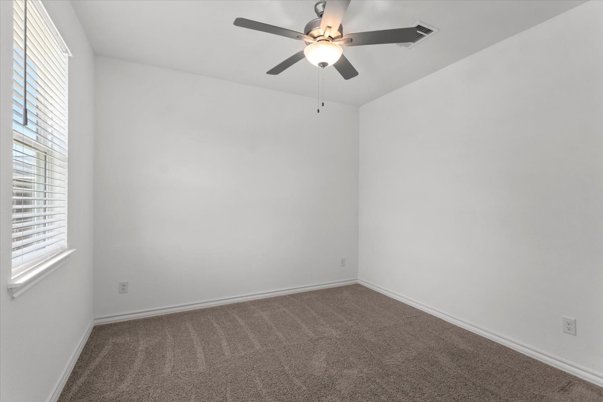 500 Stinchcomb Road Hutto, TX 78634 - Photo 30 of 37 An inviting sleeping space with soft carpeting and a window for natural light.
