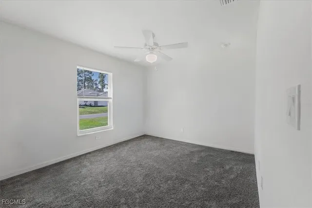 an empty room with a window and a ceiling fan