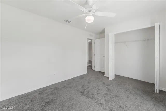an empty room with a ceiling fan and a fan
