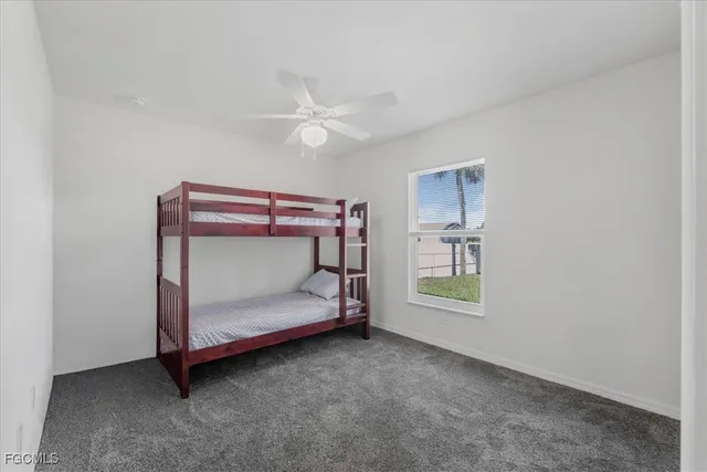 a room with a bed and a ceiling fan