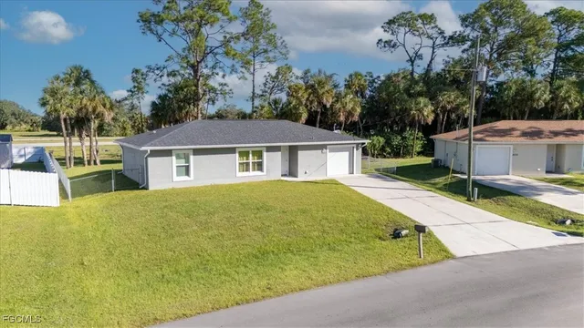 a view of a house with a backyard and a tree
