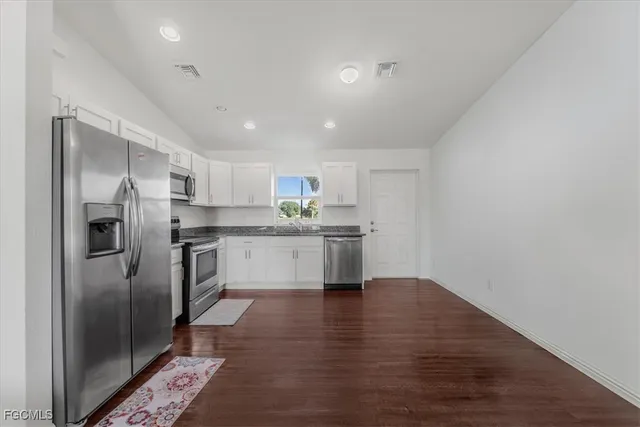 a kitchen with stainless steel appliances a refrigerator sink and cabinets