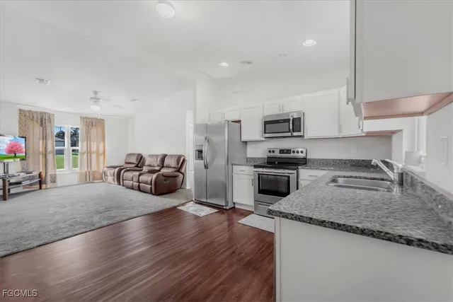 a kitchen with sink a stove and cabinets