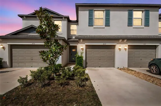 a view of a house with large windows and a small yard