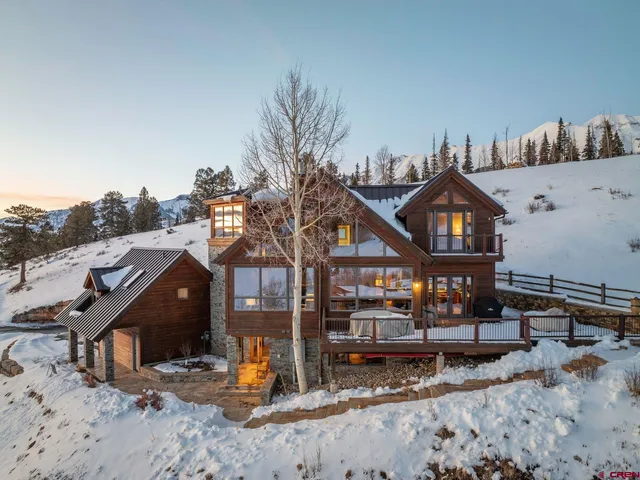 a view of a house with wooden fence next to a road