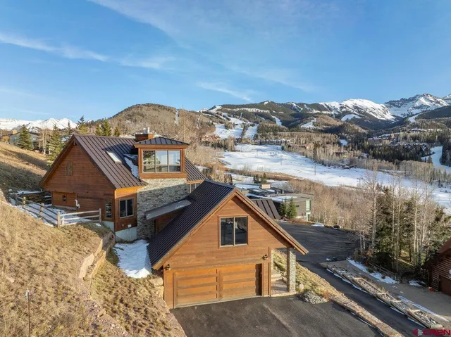 an aerial view of a house with a yard and sitting area