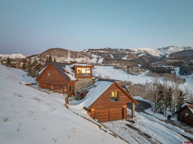 a view of a house with a snow in the background