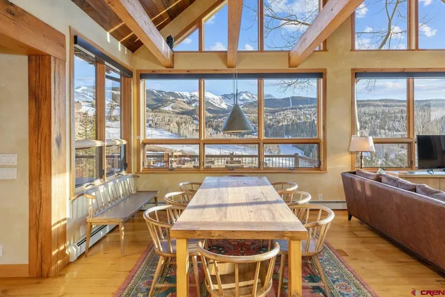 a dining room with furniture large windows and a chandelier