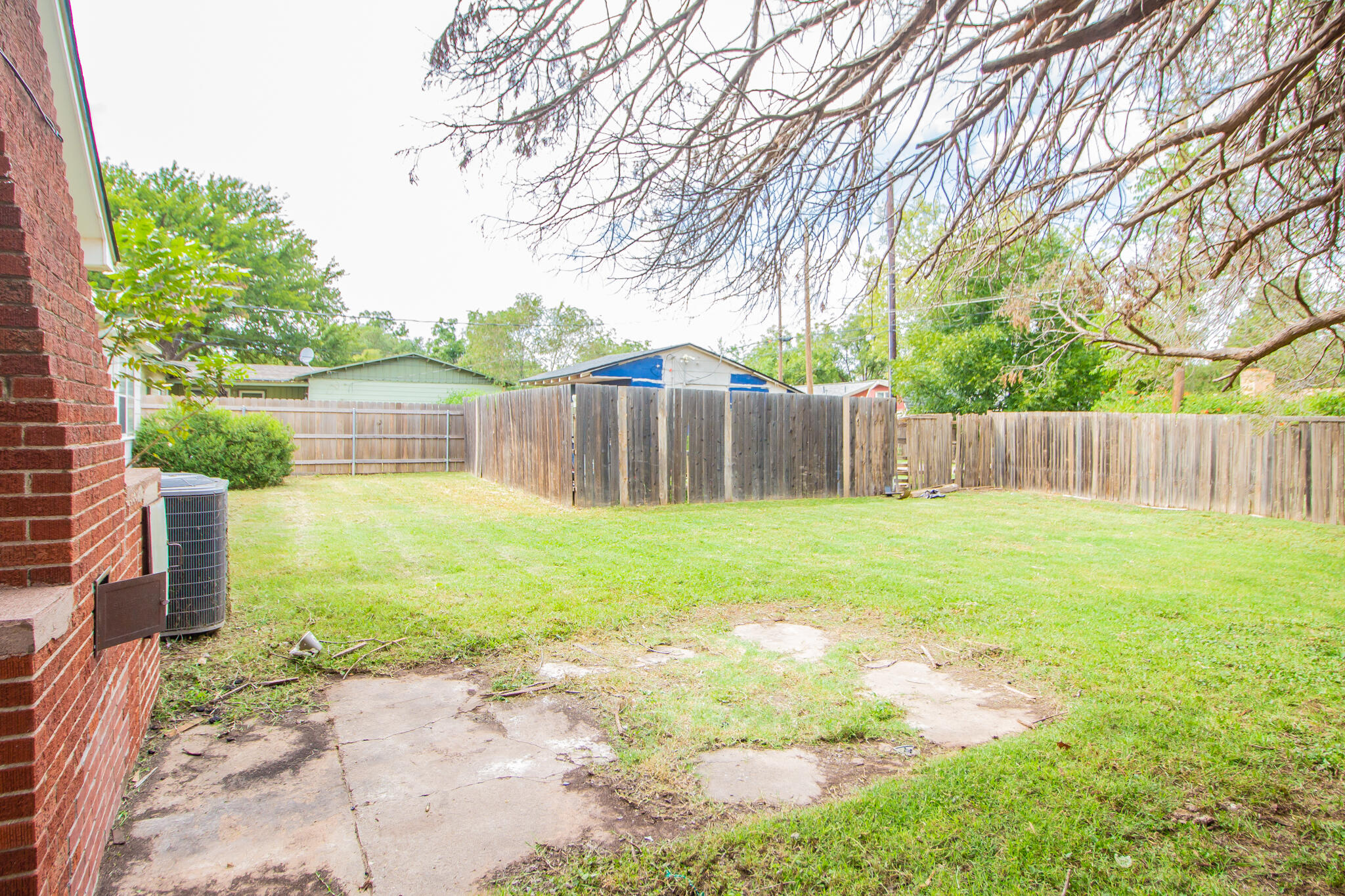 3214 27th Street Lubbock, TX 79410 - Photo 17 of 19 a view of a yard with swimming pool and wooden fence