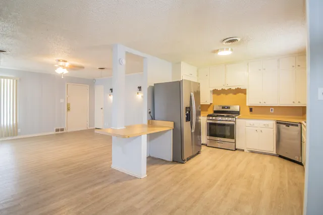 a kitchen with stainless steel appliances a refrigerator and a stove top oven