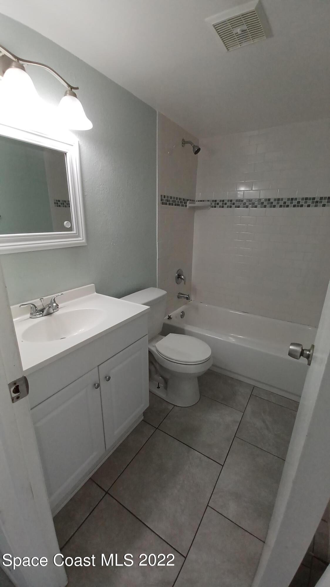 181 Ulster Lane Melbourne, FL 32935 - Photo 15 of 29 a bathroom with a sink toilet and mirror