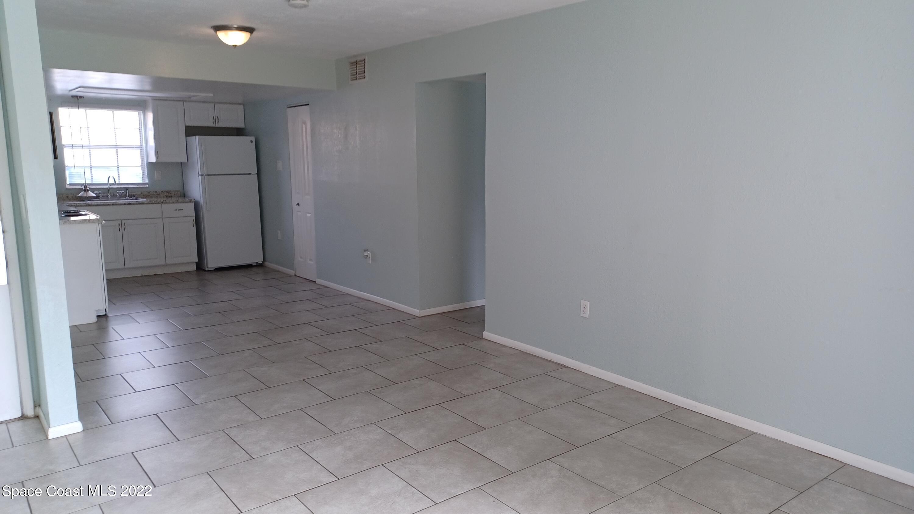 181 Ulster Lane Melbourne, FL 32935 - Photo 4 of 29 an empty room with a kitchen and a sink