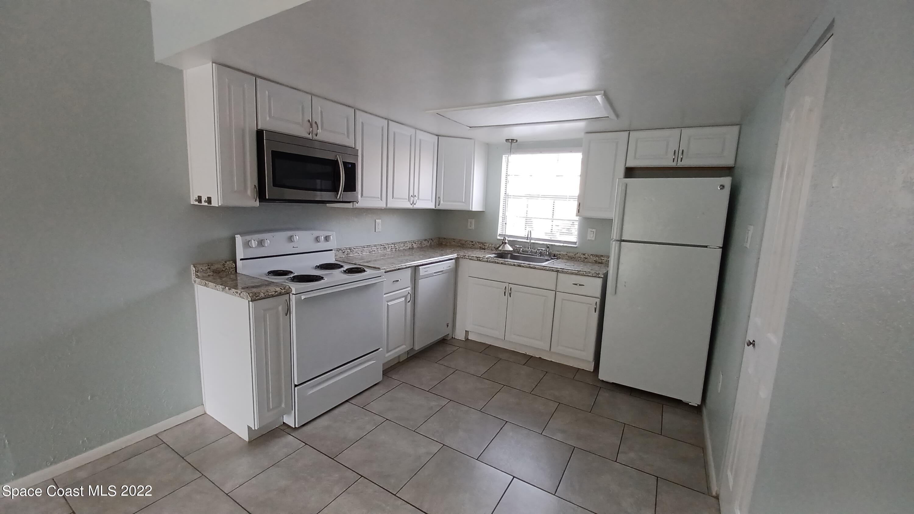 181 Ulster Lane Melbourne, FL 32935 - Photo 7 of 29 a kitchen with white cabinets stainless steel appliances and a sink