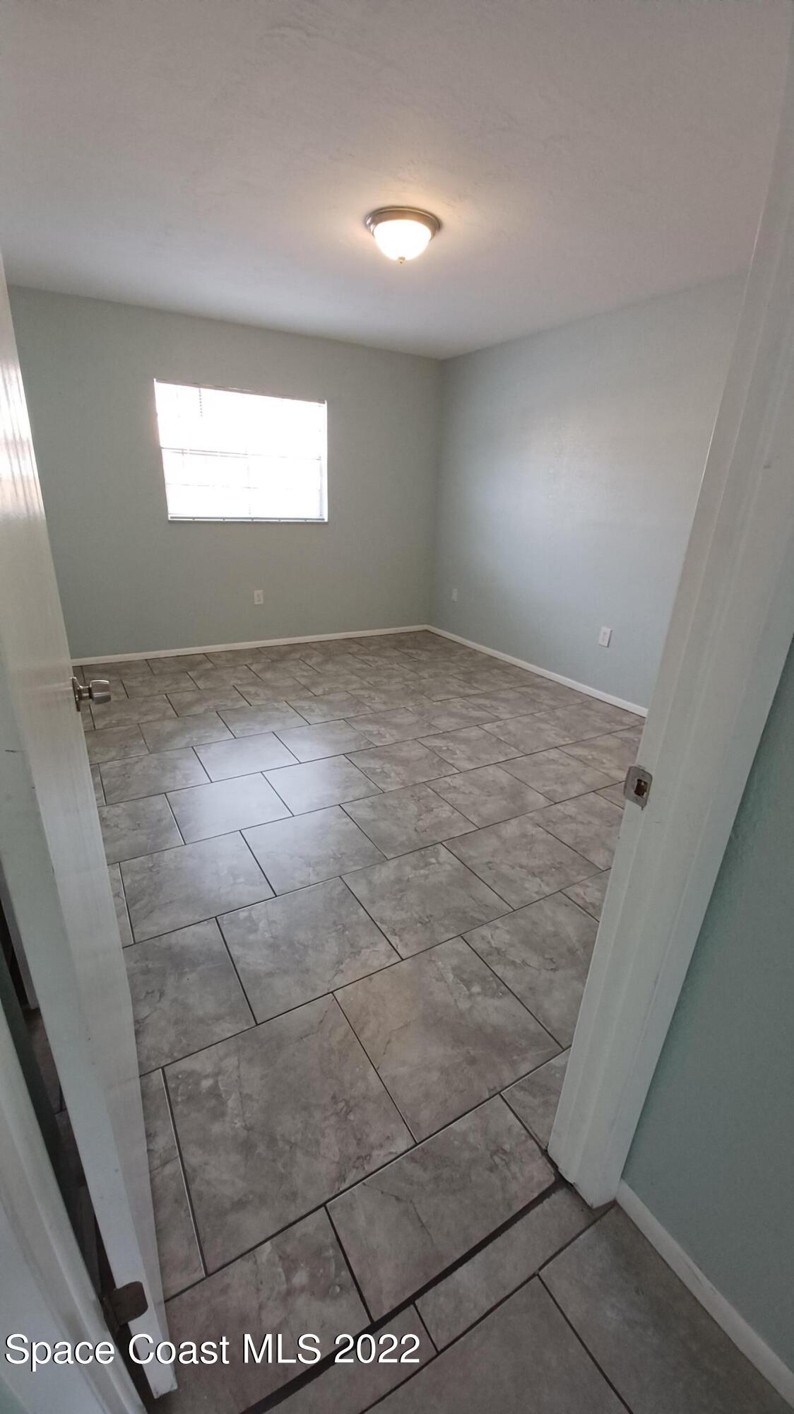 181 Ulster Lane Melbourne, FL 32935 - Photo 9 of 29 an empty room with windows