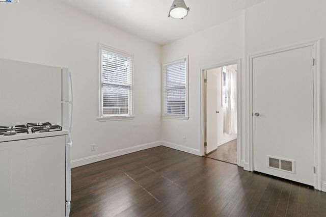 a kitchen with cabinets stainless steel appliances and wooden floor