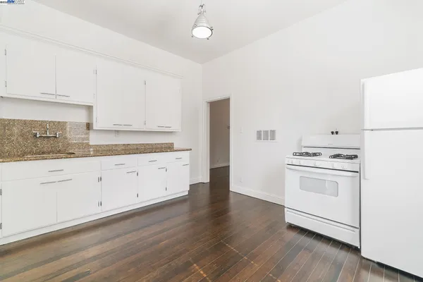 a view of kitchen with wooden floor and electronic appliances