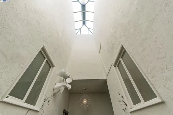 a view of stairs and utility room with windows