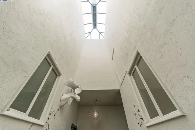 a view of stairs and utility room with windows