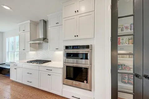 a large kitchen with stainless steel appliances kitchen island a stove a refrigerator a oven and a sink with large countertops