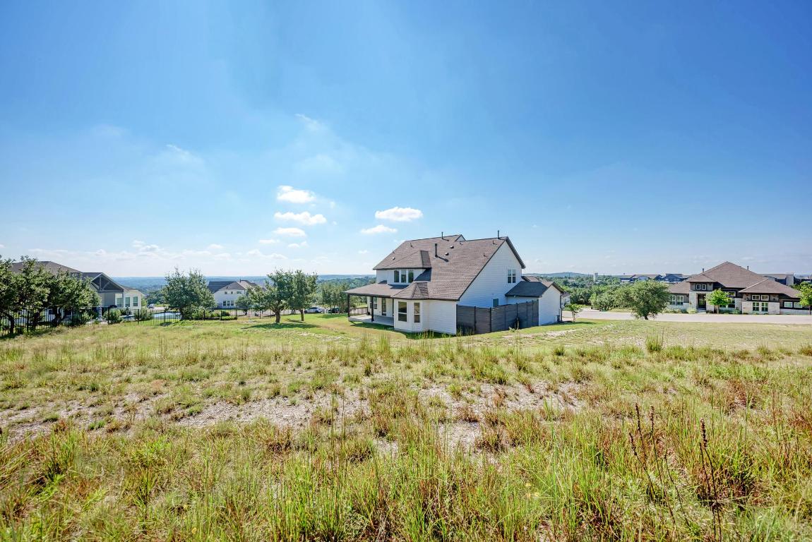 156 Verdejo Drive Dripping Springs, TX 78620 - Photo 36 of 40 a view of a big house with a big yard and large trees