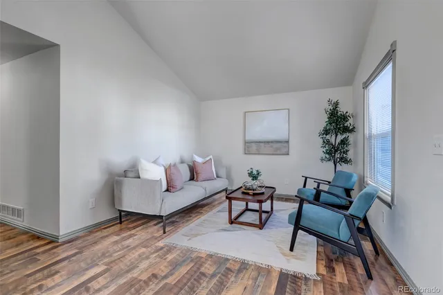 a living room with furniture and a potted plant