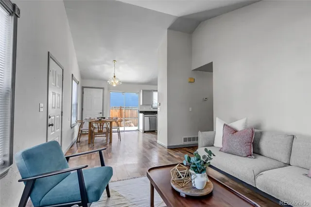 a living room with furniture kitchen and a chandelier