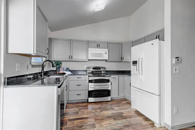 a kitchen with a stove a refrigerator and a sink