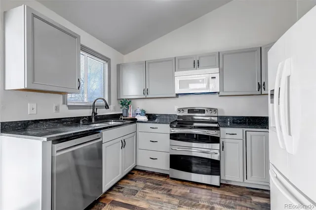 a kitchen with stainless steel appliances granite countertop a stove and white cabinets