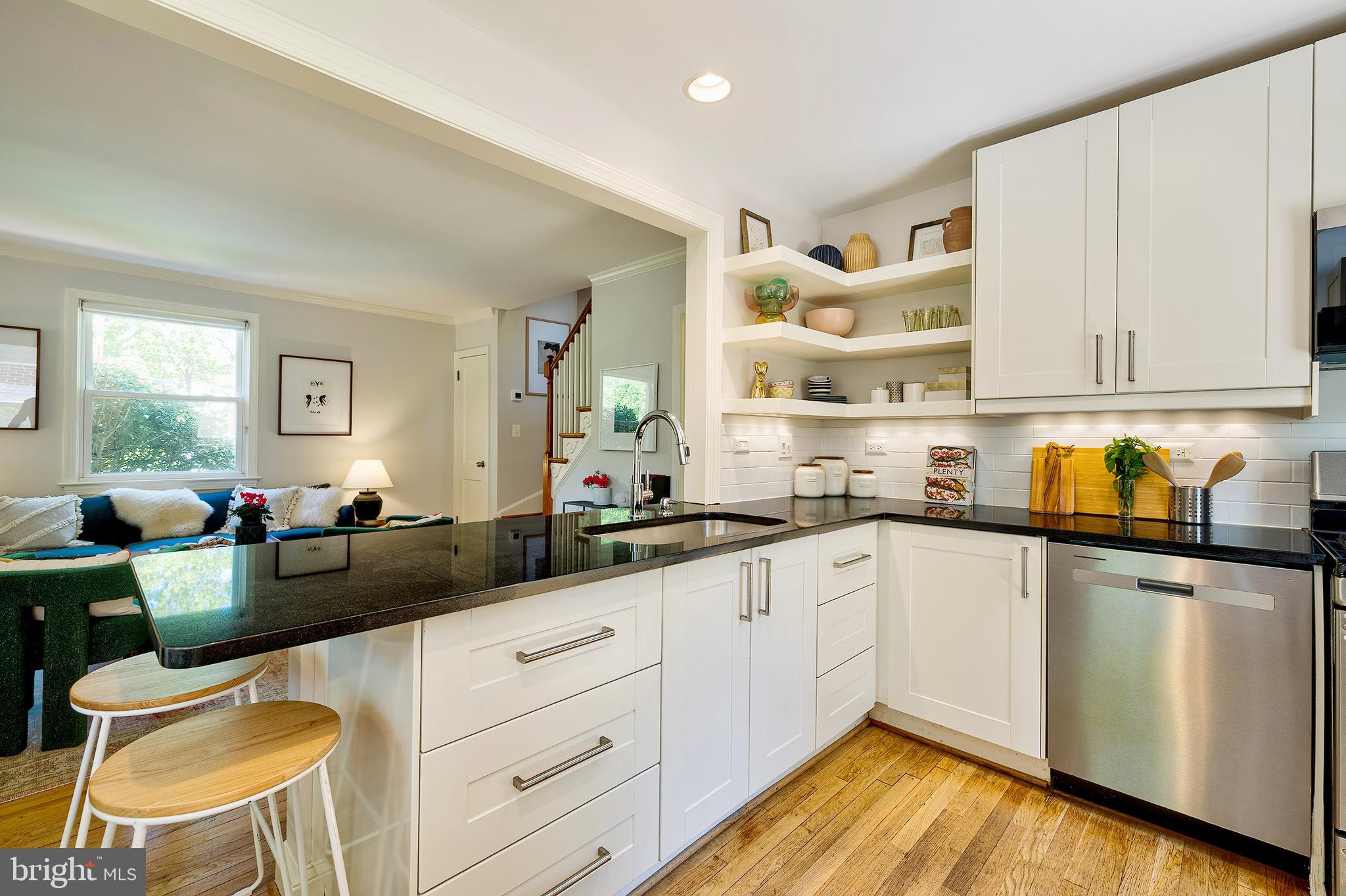 1730 Dublin Drive Silver Spring, MD 20902 - Photo 11 of 50 a kitchen with a sink dishwasher a stove and white cabinets with wooden floor