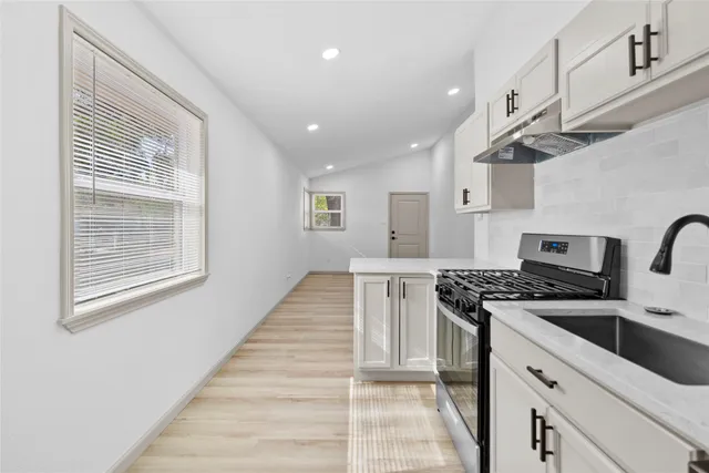 a kitchen with stainless steel appliances granite countertop a stove and a sink