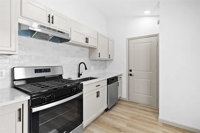a kitchen with stainless steel appliances granite countertop a stove and a microwave