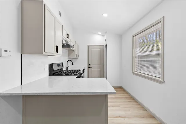 a kitchen with stainless steel appliances a sink stove and cabinets