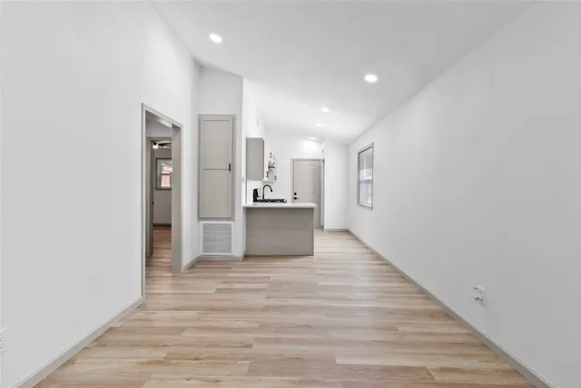 a view of a kitchen with wooden floor and a refrigerator