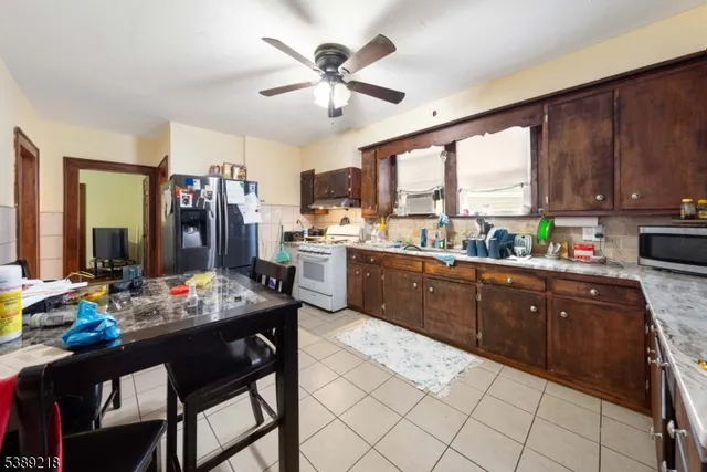 a kitchen with stainless steel appliances granite countertop a stove a sink dishwasher a stove a refrigerator with a dining table and chairs