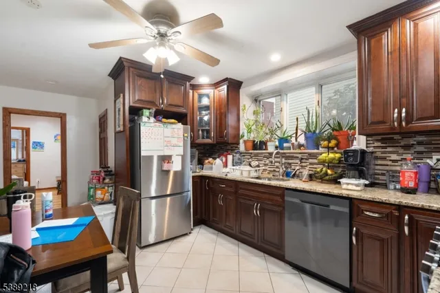 a kitchen with stainless steel appliances granite countertop sink stove top oven refrigerator and cabinets